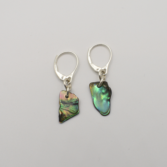 Salty Dreamers’ Earrings | Paua Shell Ra are silver leverback earrings featuring irregular, iridescent pāua shell pendants, shown on a plain white background.