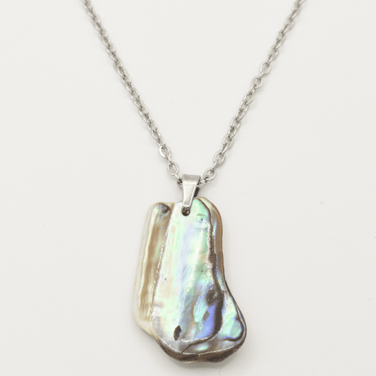 The Salty Dreamers Necklace | Paua Shell Kaukau is a handmade silver chain necklace featuring a polished, irregular abalone shell pendant with iridescent blue, green, and brown hues, shown on a white background.