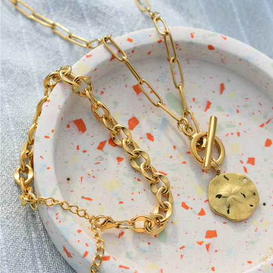 Armband Stainless Waves in Gold in einer Terrazzo-Schale