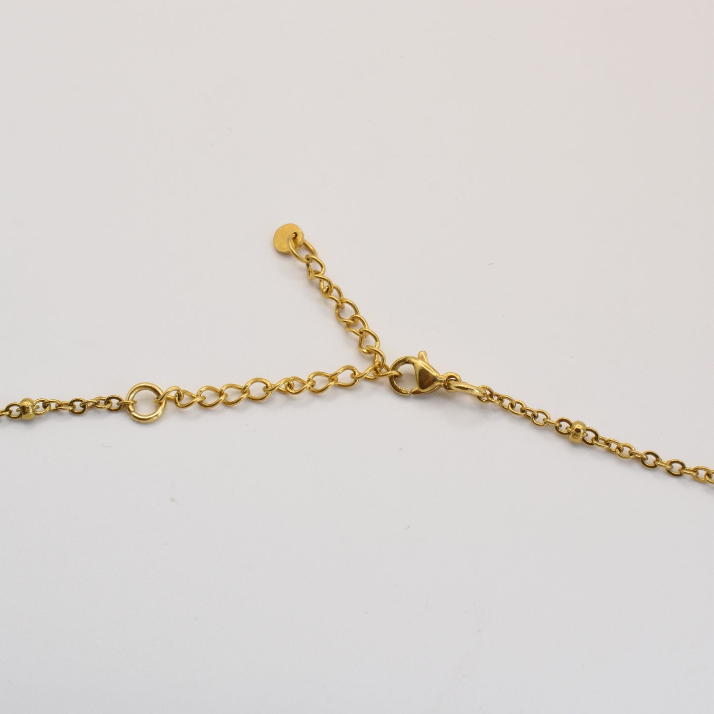 The Pretty Pearly Gold necklace by Salty Dreamers features delicate freshwater pearls, a lobster clasp, and an adjustable extension chain, shown close-up on a plain white background.