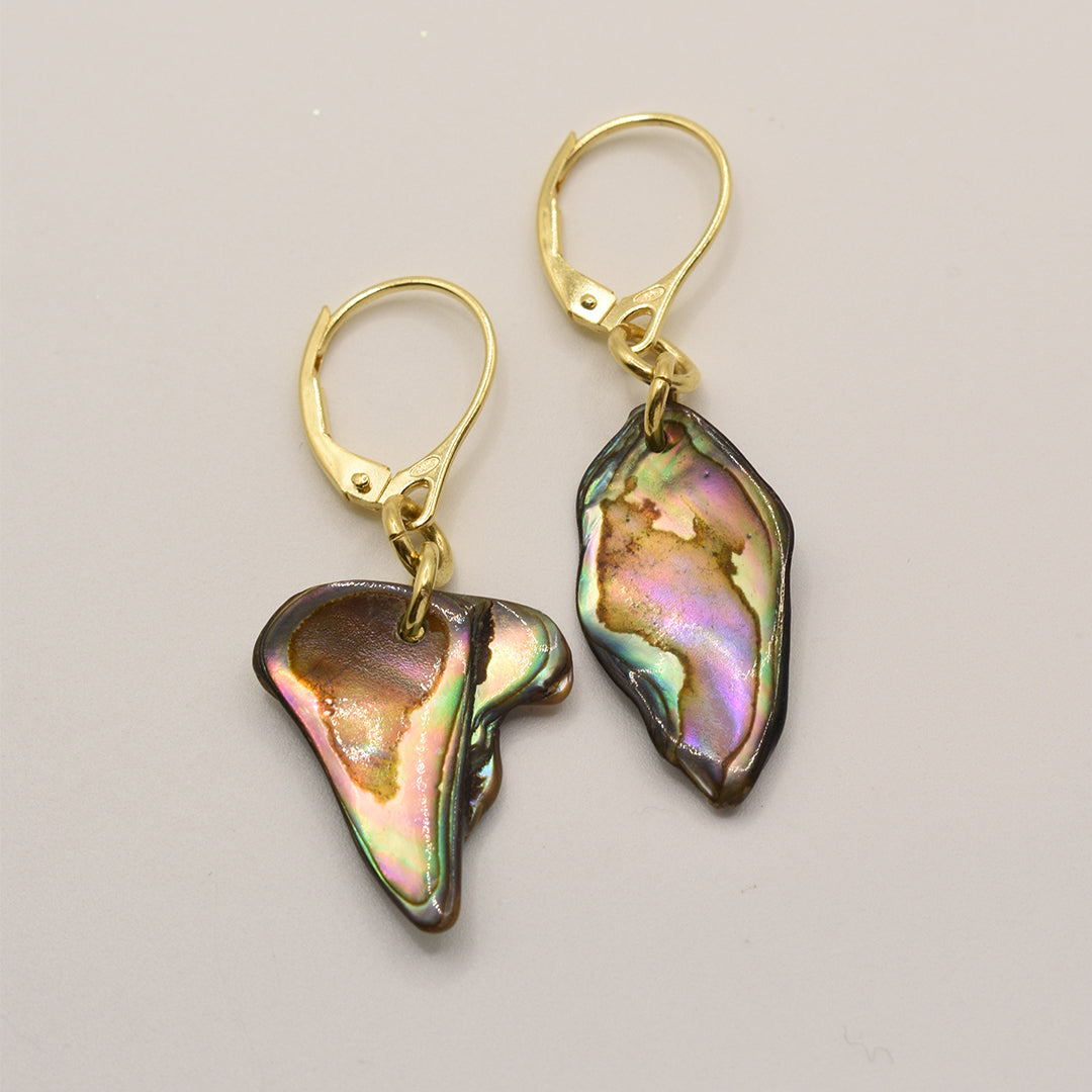 Salty Dreamers’ Paua Shell Ngakau Earrings feature gold lever-backs and handmade, iridescent New Zealand pāua shell pendants with green, pink, and purple tones on a light gray background.