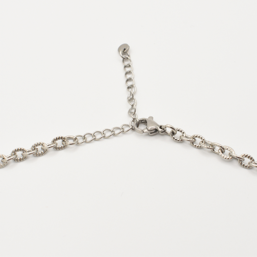 A close-up of Salty Dreamers' "Necklace | A Beach Pearl," a silver chain with lobster clasp and adjustable extension, is shown against a plain white background.