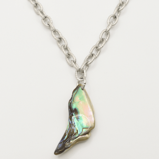 The Salty Dreamers Necklace | Paua Shell Hau features a handmade silver chain with a wing-shaped pendant, crafted from iridescent pāua shell in green, pink, and blue tones on a white background.