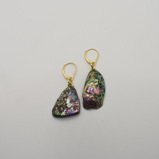 The Salty Dreamers Earrings | Paua Shell Korohea feature irregularly shaped, iridescent pāua shells with gold-plated silver lever-back hooks, shown on a plain white background.
