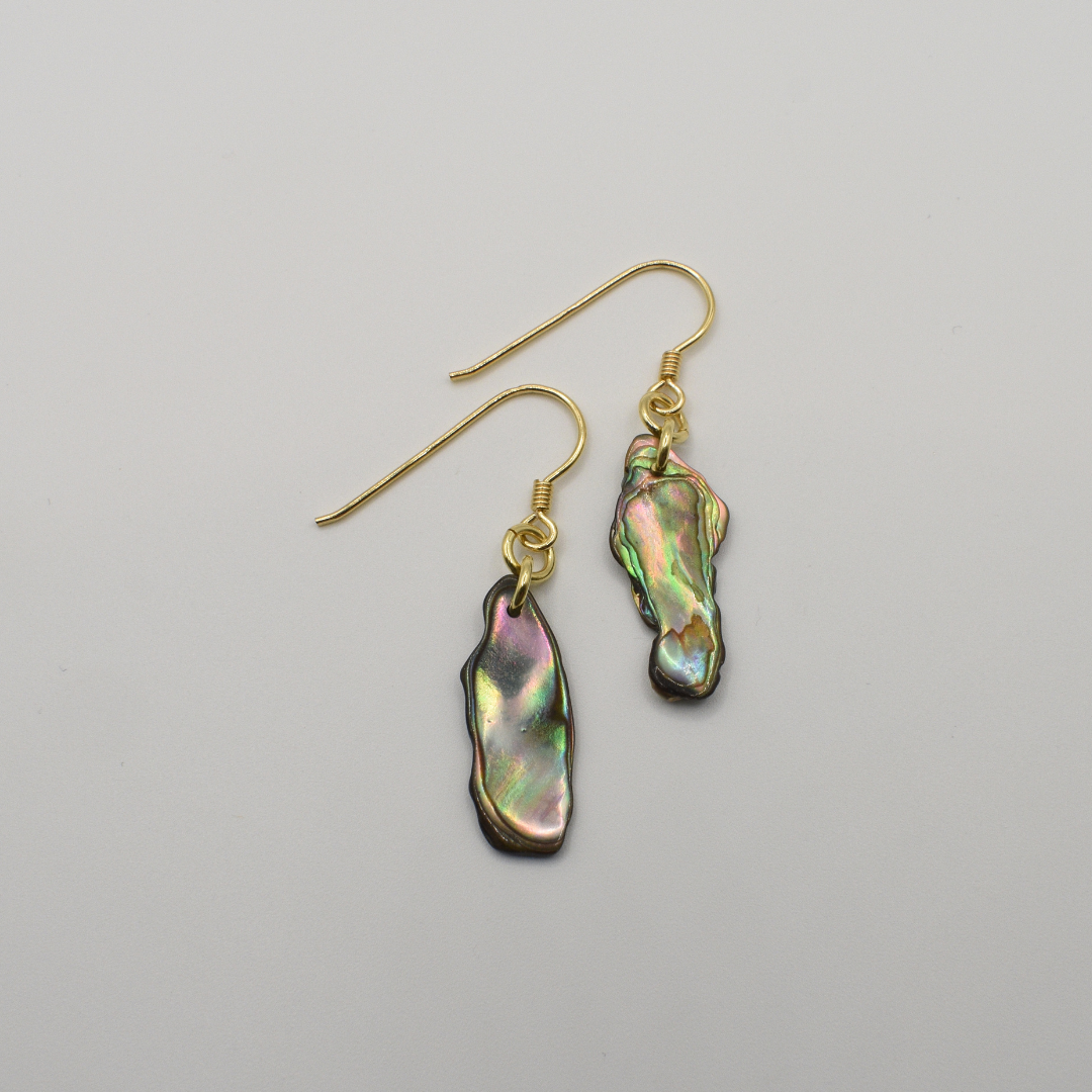 Salty Dreamers' Earrings | Paua Shell Rangi are gold-plated silver hook earrings with irregular iridescent pāua shell pendants in green, pink, and blue hues, shown on a plain white background.