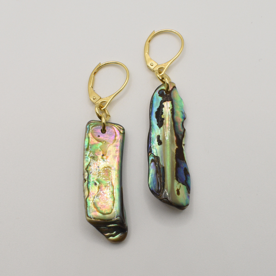 Salty Dreamers’ Earrings | Paua Shell One are gold hook earrings with irregular rectangular New Zealand paua shell pieces and an iridescent multicolored finish, shown against a plain white background.