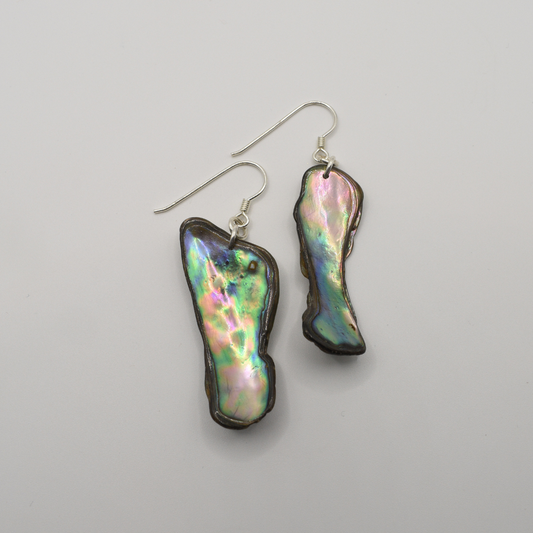 The Salty Dreamers “Earrings | Paua Shell Aroha” feature handmade, irregularly shaped iridescent paua shell pieces with silver hooks, displayed on a plain white background.