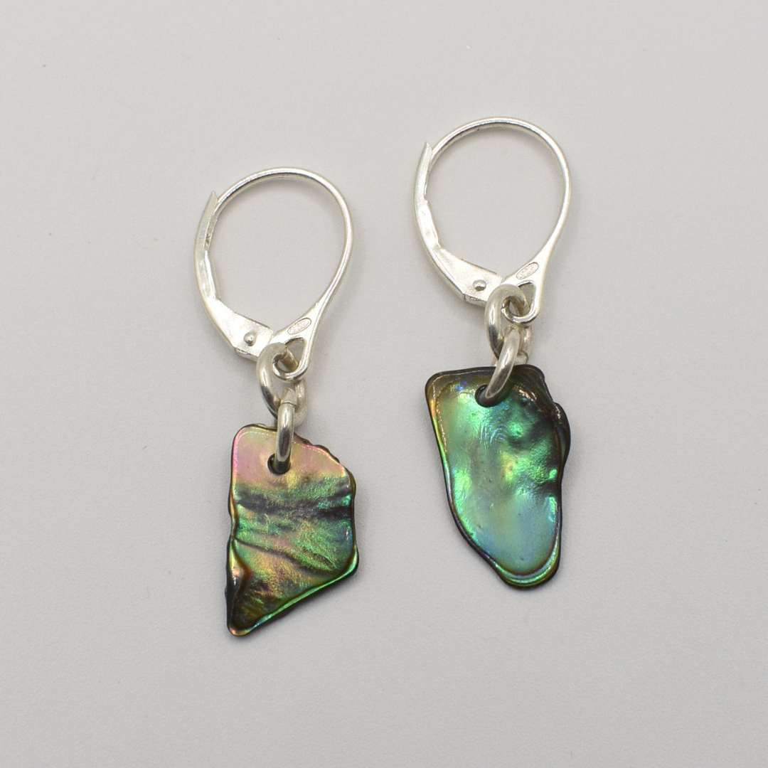 Salty Dreamers’ Earrings | Paua Shell Ra feature irregular, iridescent pāua shell pendants on silver lever-backs—ideal surfer-inspired accessories—shown against a plain light gray background.