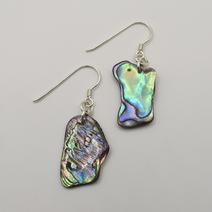 The Earrings | Paua Shell Ruru by Salty Dreamers feature handmade dangle earrings with silver hooks and unique, iridescent paua shell pendants—perfect for lovers of natural beauty. Shown on a plain white background.