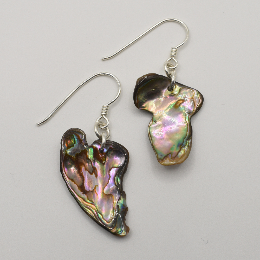 Salty Dreamers' Earrings | Paua Shell Whenua feature handmade, irregularly shaped iridescent pāua shell pendants on 925 silver hooks, shown against a plain white background.