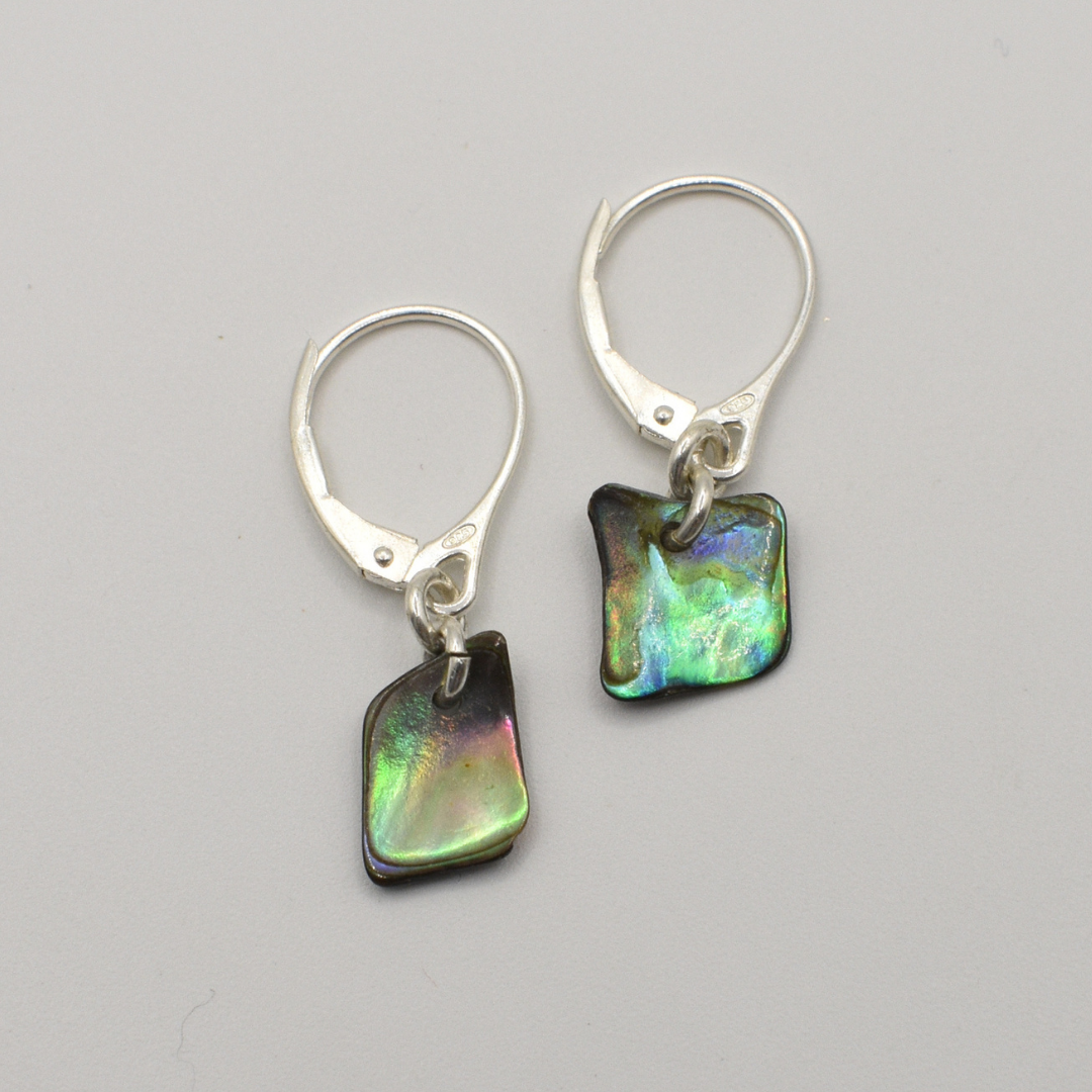 Salty Dreamers’ Earrings | Paua Shell Toroa are handmade 925 silver earrings featuring small, irregular paua shell charms with green, blue, and purple hues, shown against a plain light gray background.