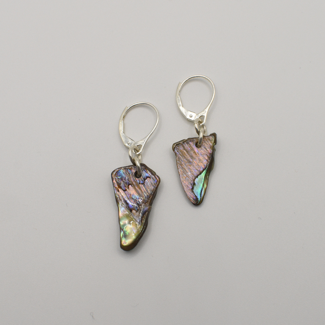 Salty Dreamers’ Earrings | Paua Shell Tai feature handmade, irregular iridescent pāua shell pieces set in 925 silver lever-back hooks, shown against a plain light gray background.
