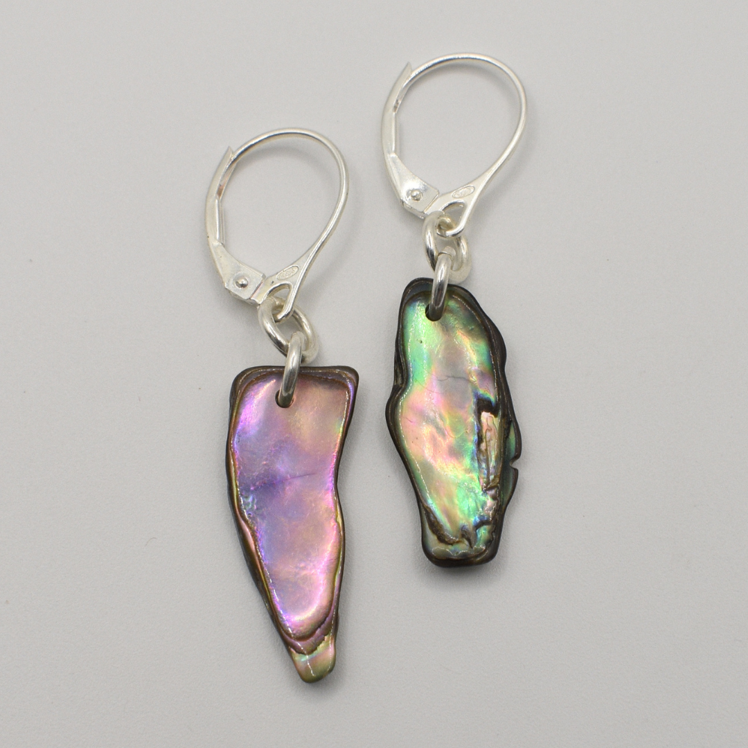 Salty Dreamers’ Earrings | Paua Shell Hine feature handmade, irregular iridescent paua shell pieces with silver hooks, displayed on a light gray background.