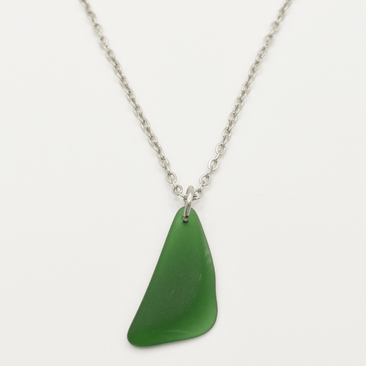 The Salty Dreamers Necklace | Green Sea Glass features a unique, irregular green sea glass pendant on a silver chain—ideal for lovers of distinctive stainless steel jewelry.
