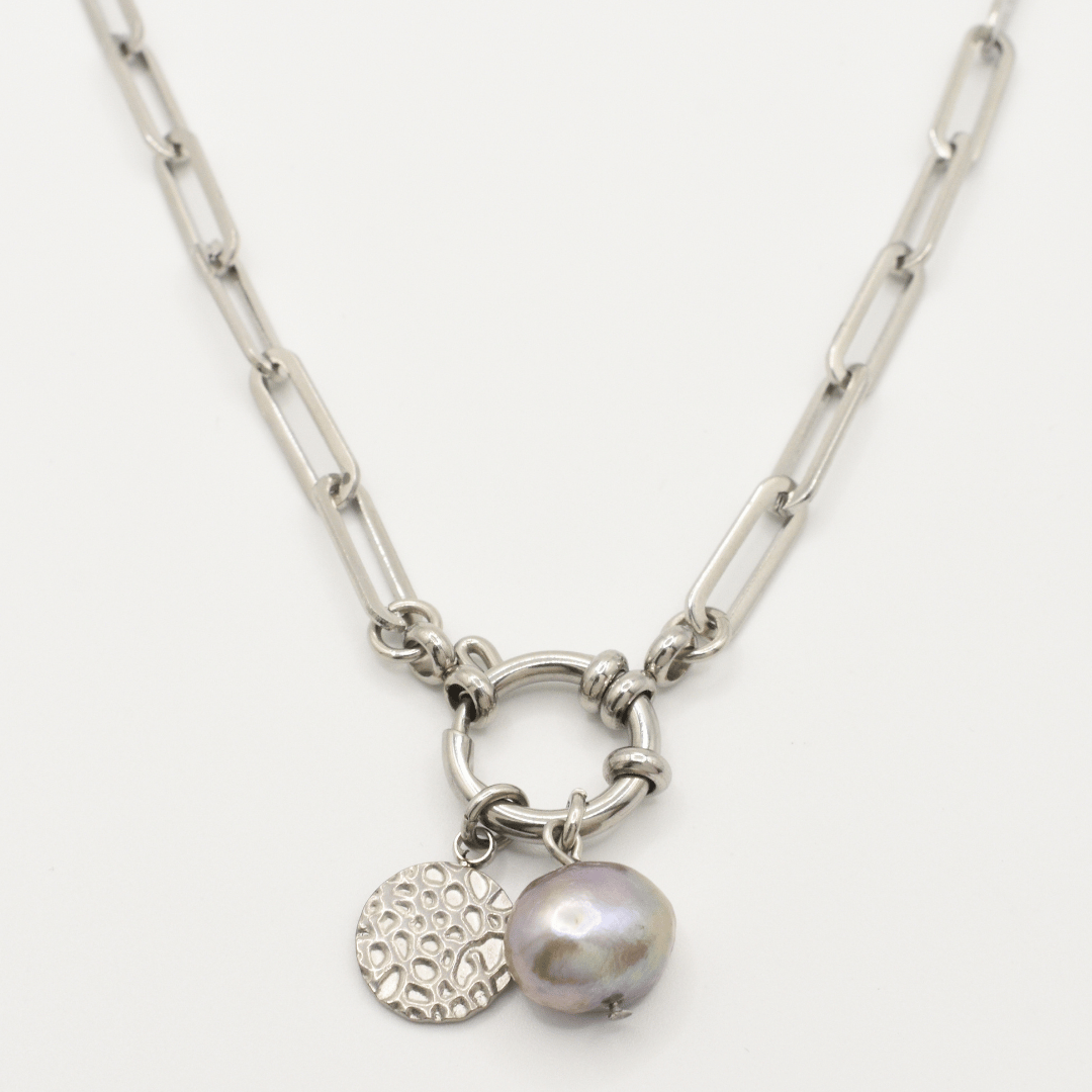 The Salty Dreamers "A Cute Couple Pearl" necklace features a silver chain with a round link centerpiece, a textured circular charm, and an irregular grey freshwater pearl pendant.