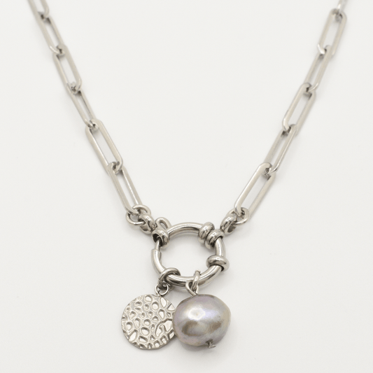 The Salty Dreamers "A Cute Couple Pearl" necklace features a silver chain with a round link centerpiece, a textured circular charm, and an irregular grey freshwater pearl pendant.