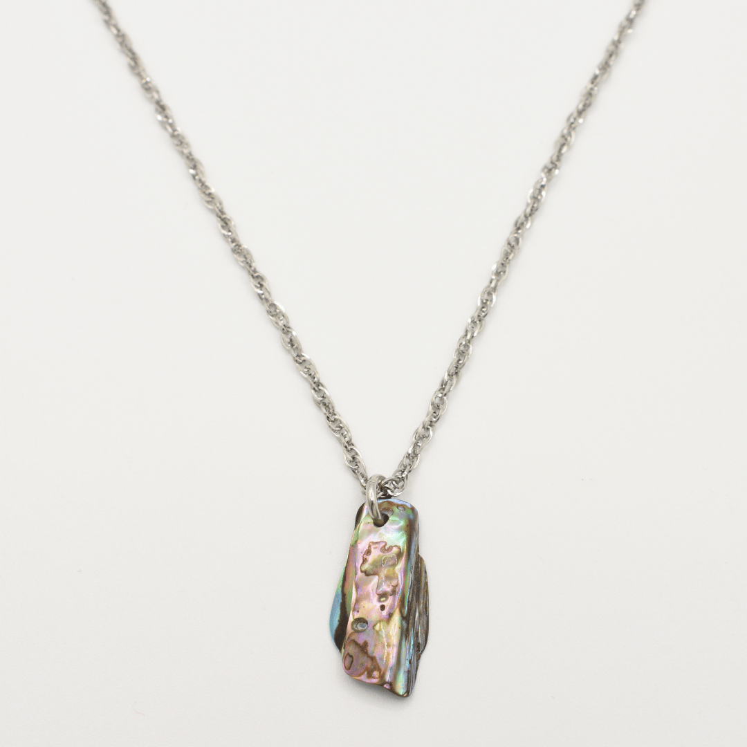 The Salty Dreamers Necklace | Paua Shell Tu features a rectangular, iridescent paua shell pendant that stands out beautifully against a plain white background.