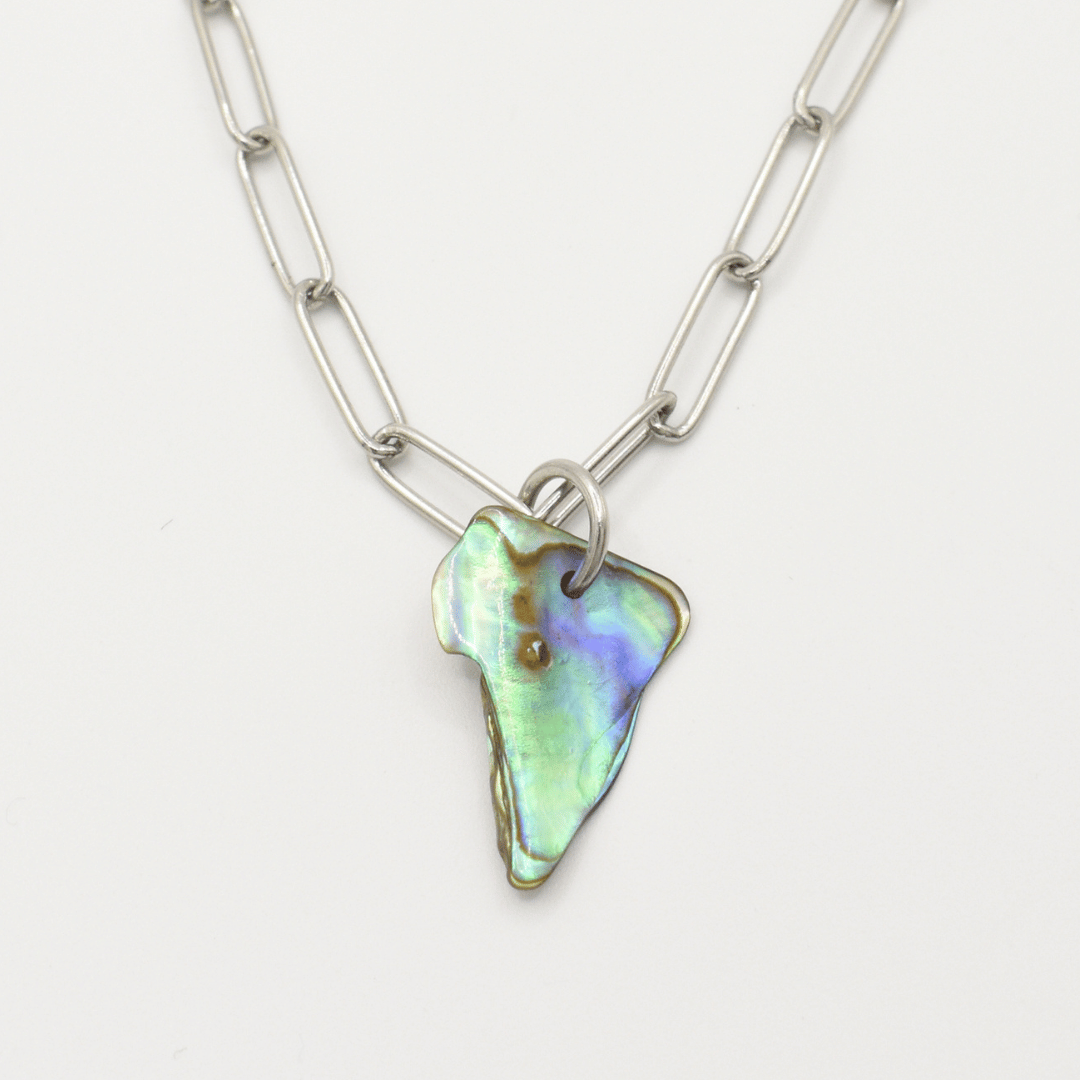 The Salty Dreamers Necklace | Paua Shell Pae is a handmade silver chain with large oval links, featuring an irregular iridescent pāua shell pendant in green, blue, and purple—a striking New Zealand jewelry piece.