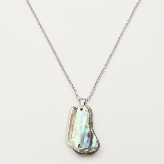 The Salty Dreamers Necklace | Paua Shell Kaukau features a handmade silver chain with an iridescent, uniquely-shaped paua shell pendant, shown on a white background.