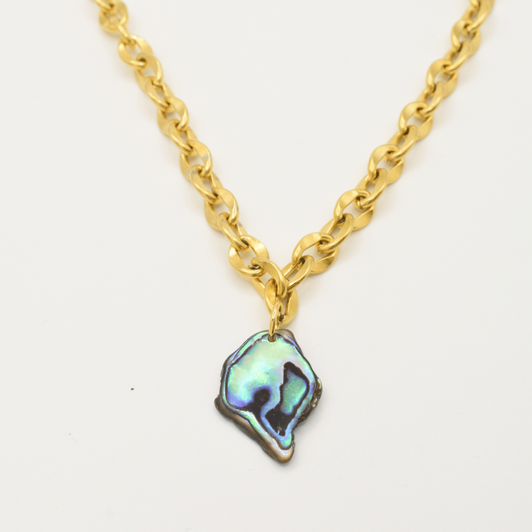 The Salty Dreamers Necklace | Paua Shell Tautahi features a chunky gold chain and an irregular, iridescent paua shell pendant. Shown on a white background, this handmade piece is bold and striking.