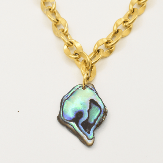 The Salty Dreamers Necklace | Paua Shell Tautahi features a chunky gold chain and a handmade abalone pendant with an iridescent, irregular pāua shell showcasing stunning blue, green, and black hues.