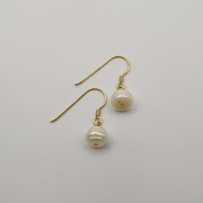 The Pearl earrings by Salty Dreamers feature handmade gold settings with irregular freshwater pearl drops, shown on a plain white background.