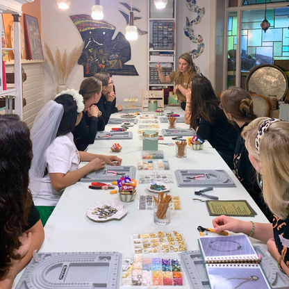 At the Salty Dreamers Workshop Ocean Jewellery in Kiel, women—including a bachelorette in a white veil—gather around a table of beads and tools, eager to craft their own jewellery as they follow the instructor’s guidance.