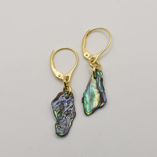 Salty Dreamers' Paua Shell Moana Earrings feature gold lever-back hooks and iridescent, irregular abalone shell dangles, displayed on a plain white background.