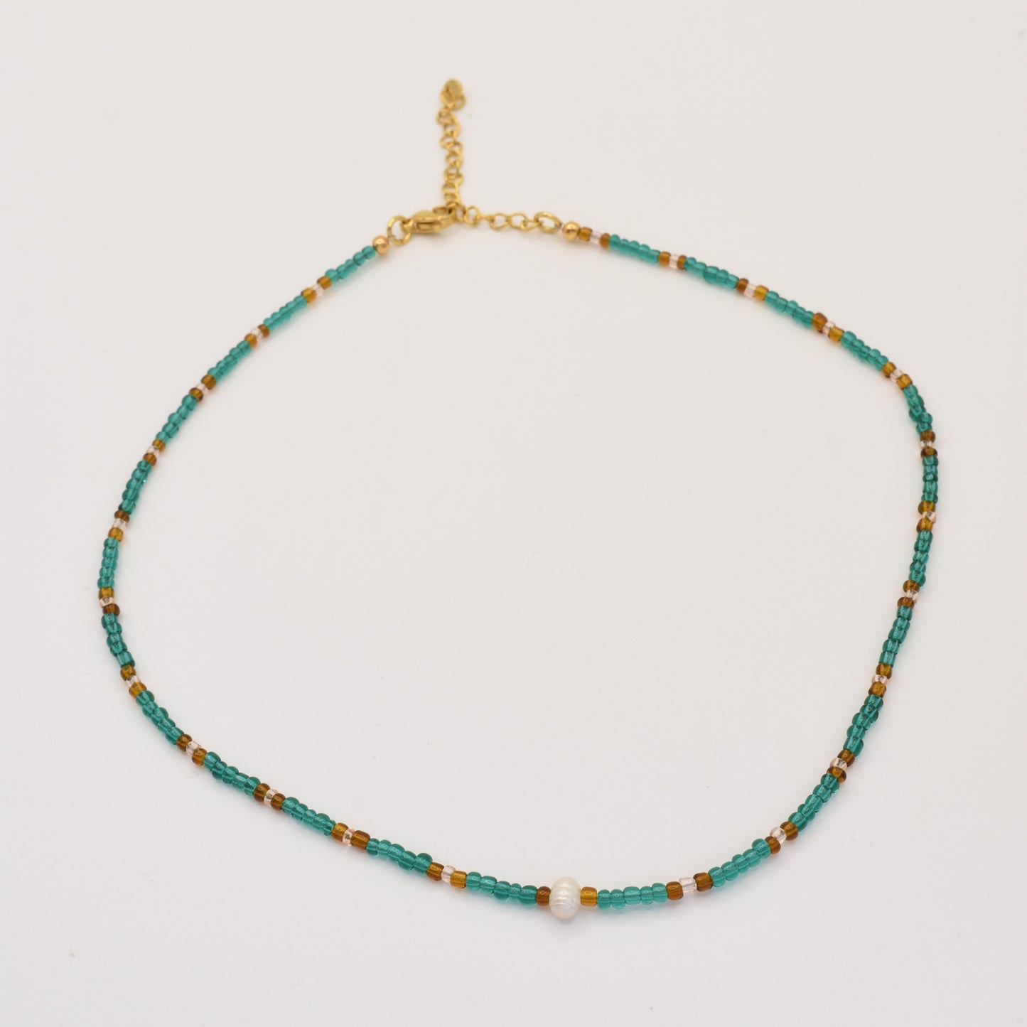 The Necklace | Fresh Beads Blue by Salty Dreamers is a handmade piece featuring turquoise, brown, and gold beads with a central freshwater pearl and an adjustable gold chain clasp, displayed on a white background.