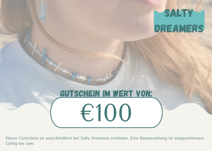 A woman wearing a beaded necklace is shown in close-up. Overlaid text reads “Gift Card Salty Dreamers: €100.” This Salty Dreamers voucher is perfect for ocean lovers and redeemable only at Salty Dreamers.
