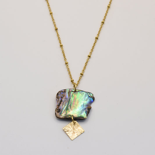 The Salty Dreamers Necklace | Paua Shell Rangi features a handmade gold chain with an iridescent New Zealand abalone pendant and a textured gold square charm, shown on a simple light background.