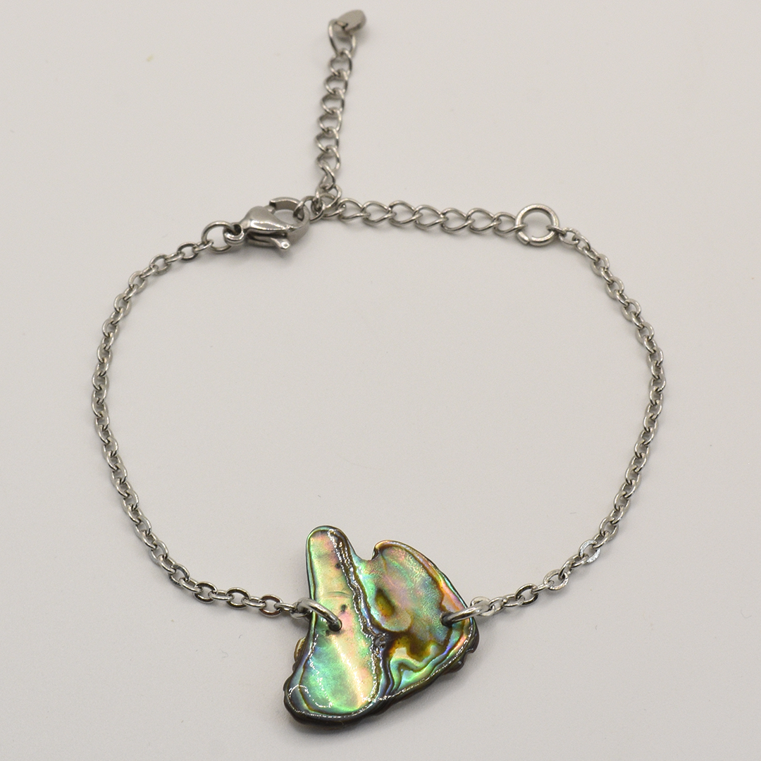 Bracelet with a paua shell on a light gray background