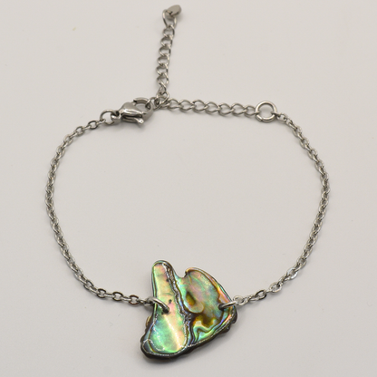 Bracelet with a paua shell on a light gray background
