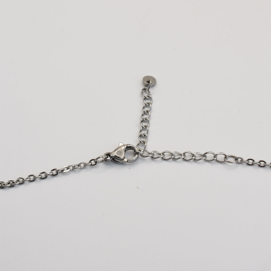 A close-up of the Salty Dreamers Necklace | Green Sea Glass, featuring a stainless steel chain with lobster clasp and adjustable extender, shown on a plain white background.