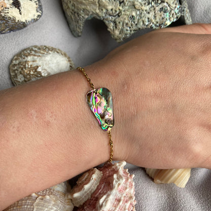 golden stainless steel abalone shell bracelet on womans arm