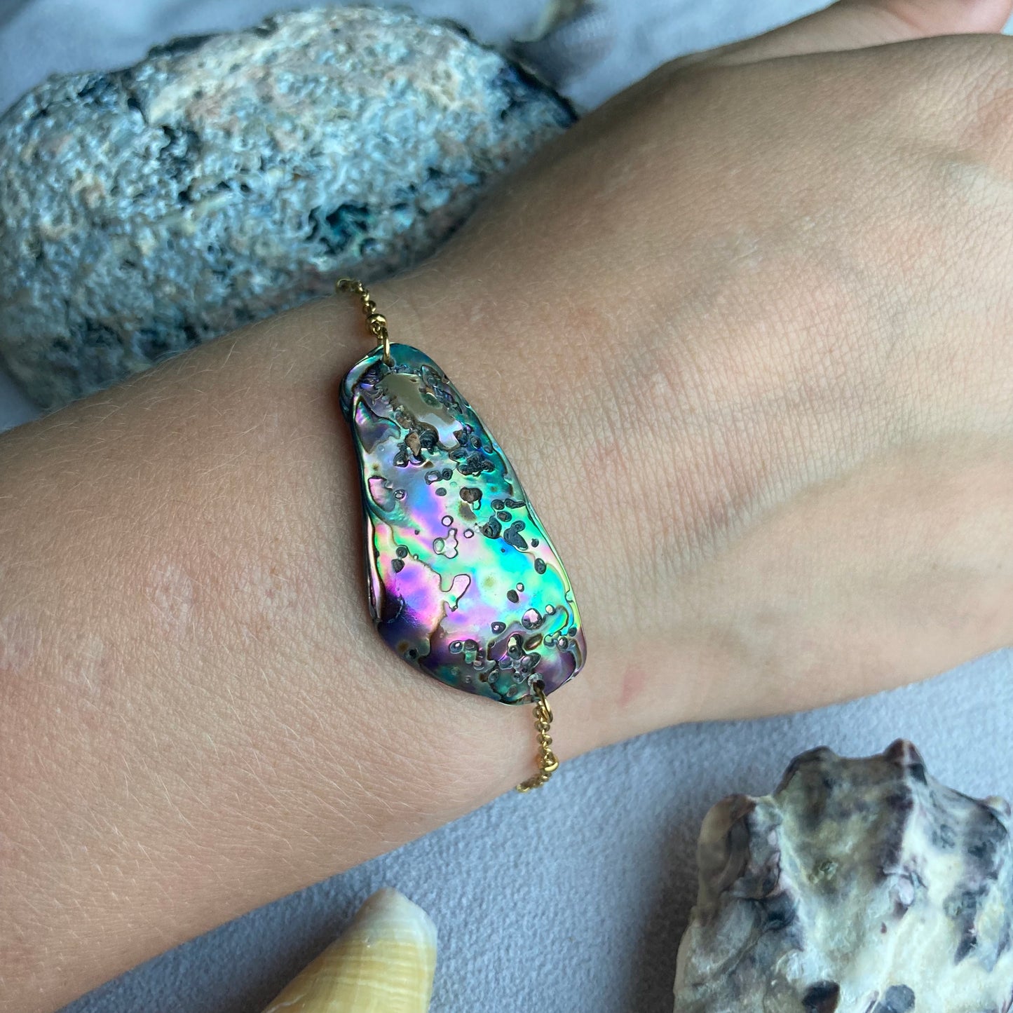 A golden paua shell bracelet stainlss steel on wrist